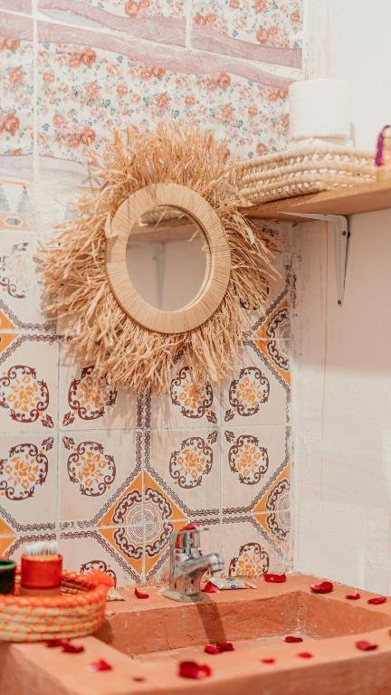Hammam traditionnel du riad, murs en tadelakt gris, seau en laiton et étoiles de lumière percées dans la voûte